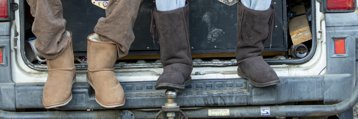 Men sitting in boot wearing Ugg Boots - Chestnut and Black in colour - 2.